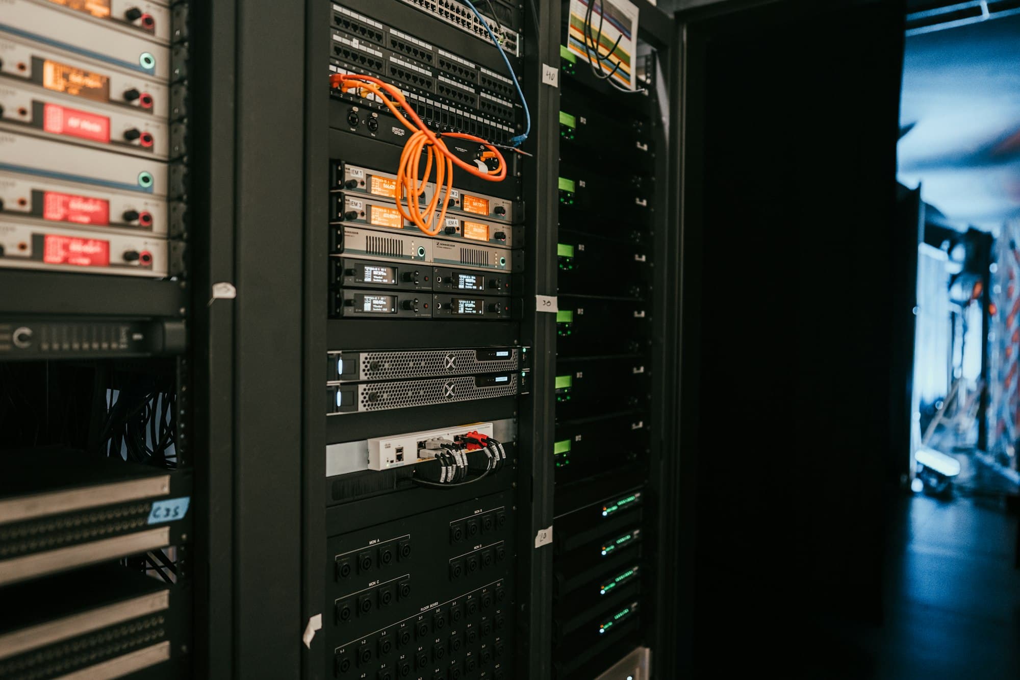 A rack of servers seen close up, status lights lit across the units