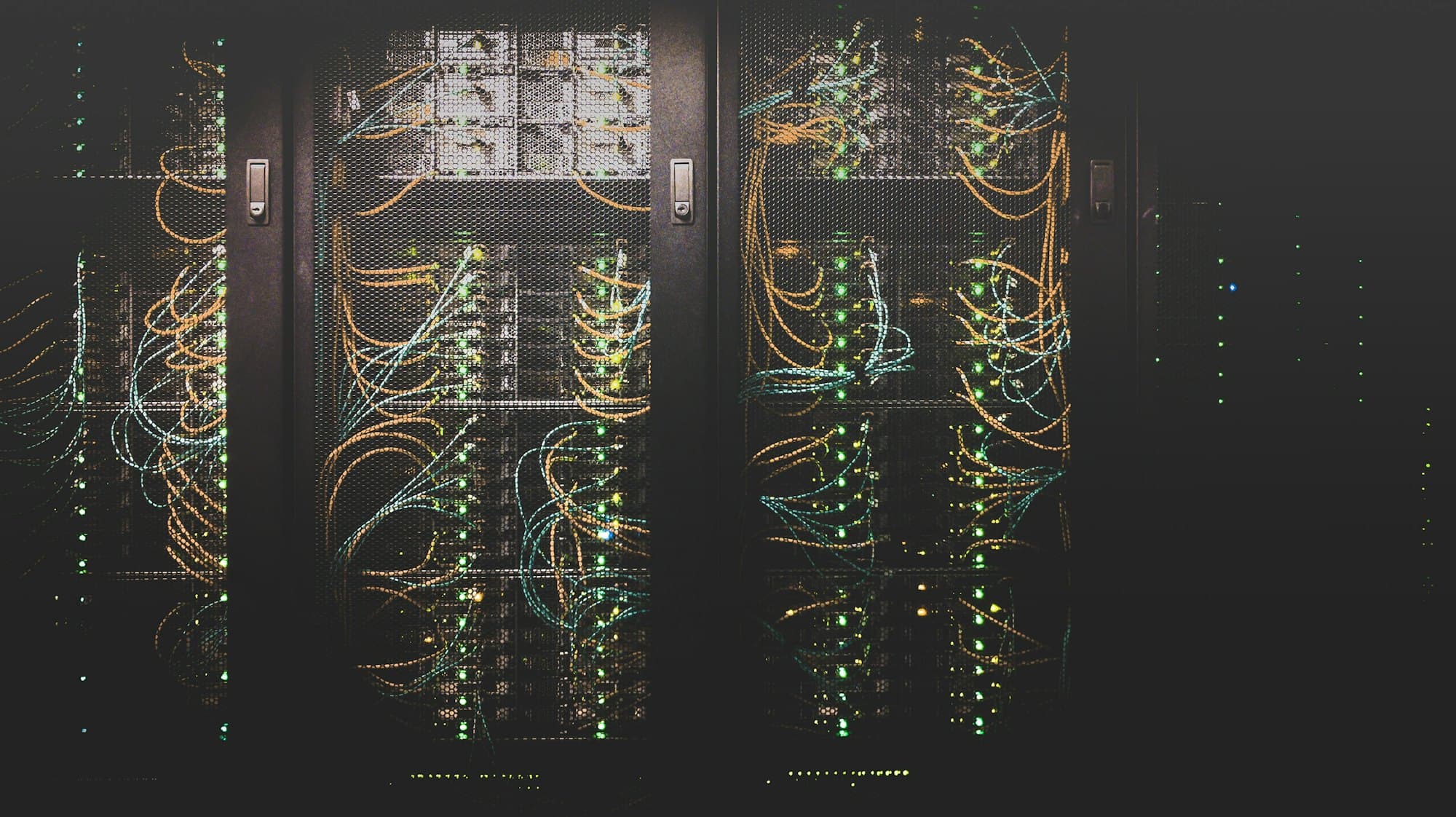 A dark server hall, patch cables running between racks